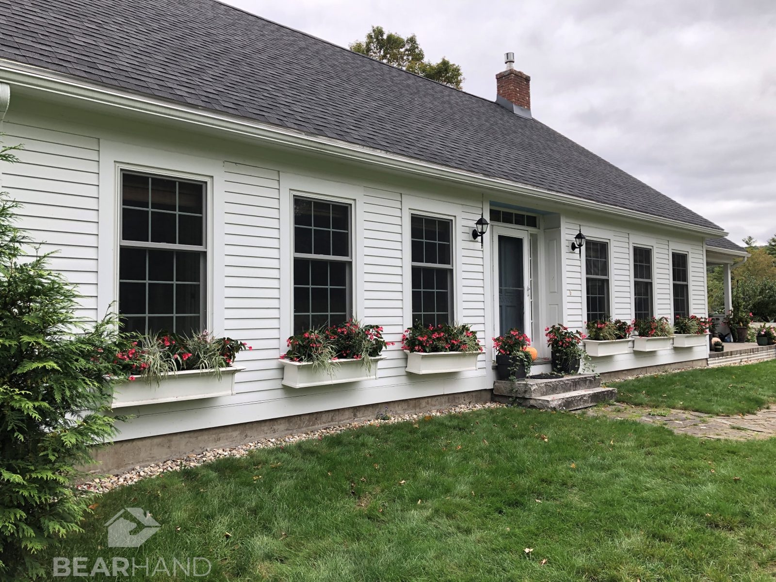 Farmhouse exterior with new windows by BearHand Construction