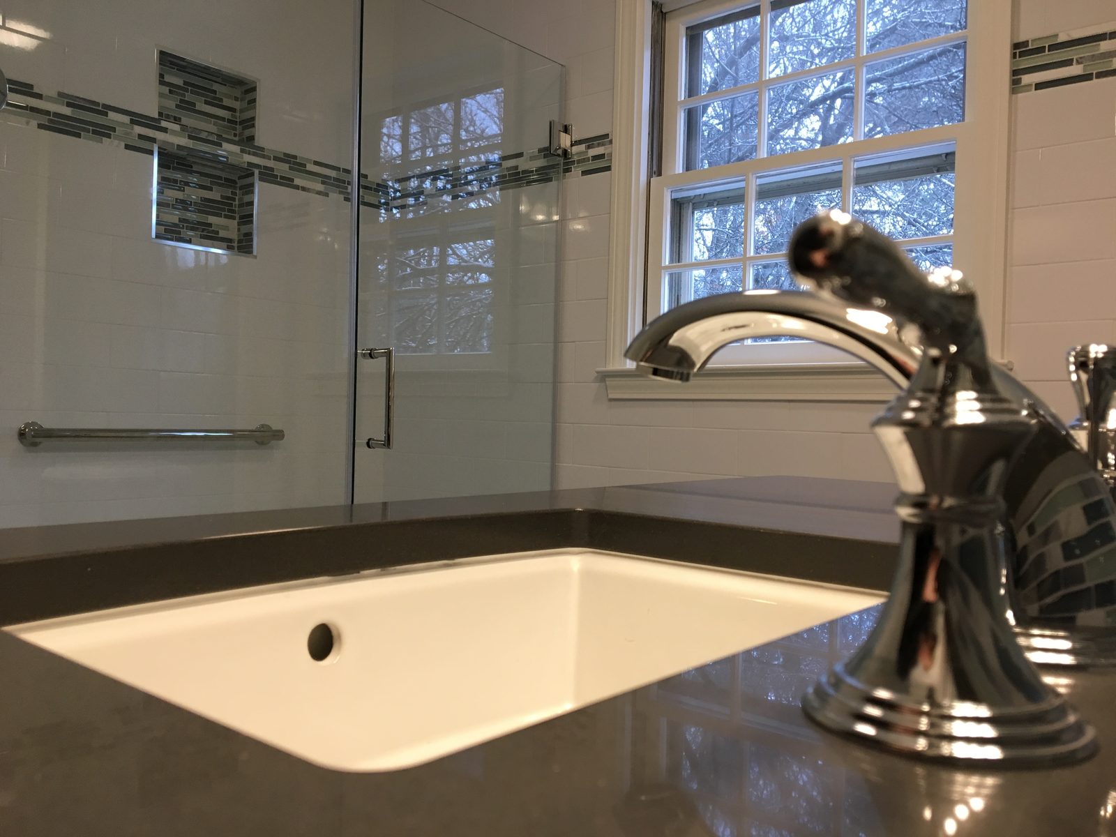 Walk-in shower with glass enclosure by BearHand Construction